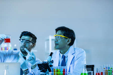 Team of research scientists analysing test trial new generation vaccine data. They work in a modern laboratory/ Medical center.の写真素材