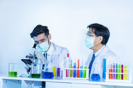 Team of research scientists analysing test trial new generation vaccine data. They work in a modern laboratory/ Medical center.の写真素材