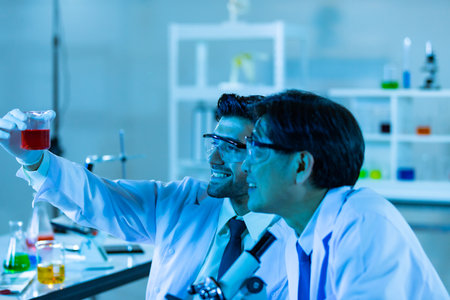Team of research scientists analysing test trial new generation vaccine data. They work in a modern laboratory/ Medical center.の写真素材