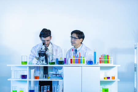 Team of research scientists analysing test trial new generation vaccine data. They work in a modern laboratory/ Medical center.の写真素材