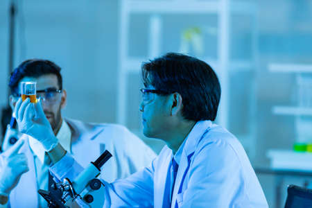 Team of research scientists analysing test trial new generation vaccine data. They work in a modern...