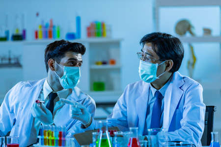 Team of research scientists analysing test trial new generation vaccine data. They work in a modern laboratory/ Medical center.の写真素材