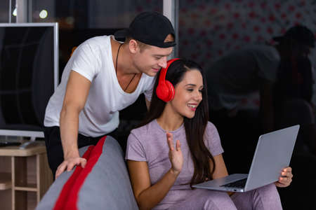 Romantic couple VIDEO call with feeling happy in their living room by using laptop computer.の写真素材