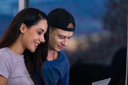 Young couple relaxing and enjoying at home on sofa with laptop. Concept happy couple.の写真素材