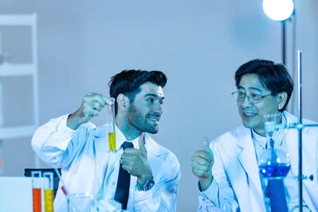 Team of research scientists analysing test trial new generation vaccine data. They work in a modern laboratory/ Medical center.の写真素材