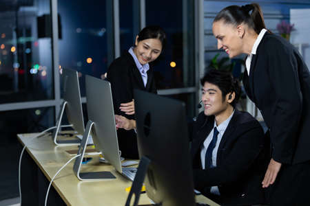 Business team working overtime late at night in call center office for support customer by online and phone. Concept for business at night.の写真素材