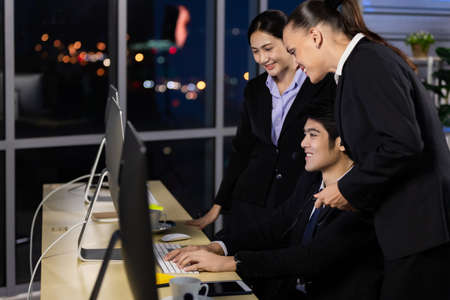 Business team working overtime late at night in call center office for support customer by online and phone. Concept for business at night.の写真素材