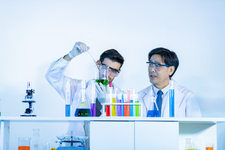 Team of research scientists analyzing test trial new generation vaccine data. They work in a modern laboratory/ Medical center.の写真素材