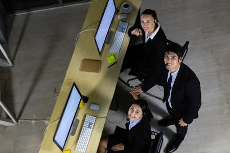 Top view of business team relaxing after working overtime late at night in call center office.の写真素材