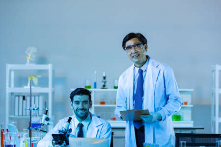 Team of research scientists analysing test trial new generation vaccine data. They work in a modern laboratory/ Medical center.の写真素材