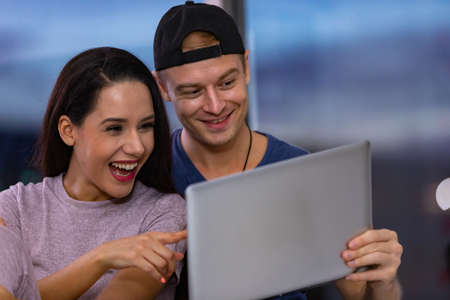 Young couple relaxing and enjoying at home on sofa with laptop. Concept happy couple.の写真素材