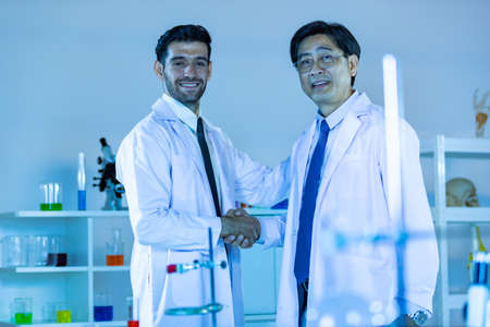 Two scientists shaking hands positivity success happiness. Concept collaboration between Caucasians...
