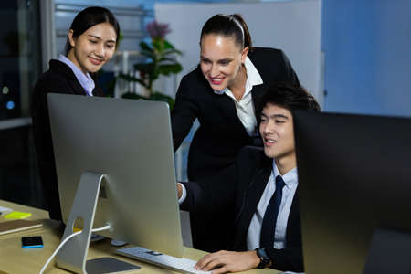 Business team working overtime late at night in call center office for support customer by online and phone. Concept for business at night.の写真素材