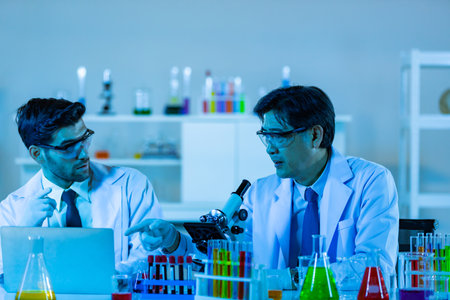 Team of research scientists analysing test trial new generation vaccine data. They work in a modern laboratory/ Medical center.の写真素材