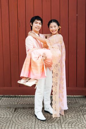 Asian Thai groom is carrying his bride in smiling face.の写真素材