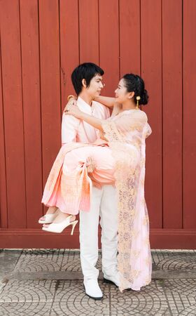 Asian Thai groom is carrying his bride in smiling face.の写真素材