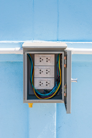 Wrapped White Electric Power Outlet in Gray Cabinetの写真素材