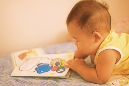 lovely baby girl reading bookの写真素材