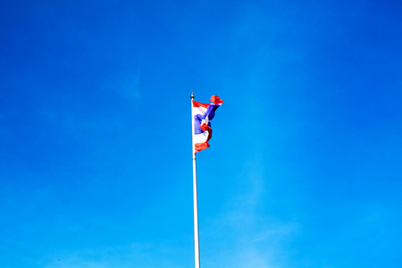 Image of waving Thai flag of Thailand with blue sky background.