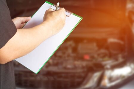 Asia foreman hold check sheet paper for maintenance concept of carの写真素材