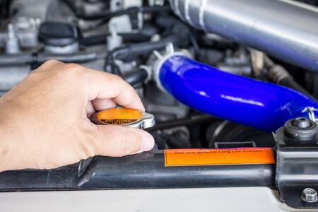 Hand a man close a cap of radiator on car check and service concept in the engine roomの写真素材