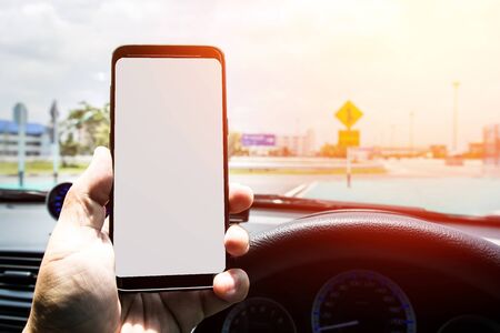 Hand a man hold the smart phone in the car for open Application on the phone Traveling convenience...