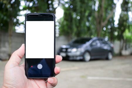 Asia man use smart phone with photograph car Location recognition and  safety concept of parking...