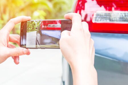 Women use smart phone take photos accident of car for insurance conceptの写真素材