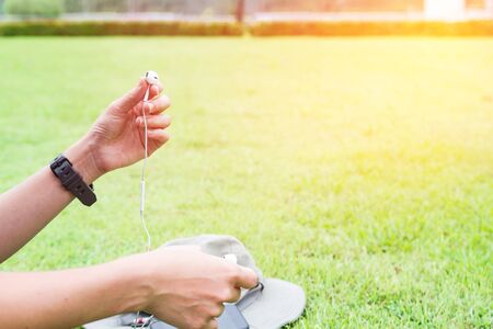Close up woman hands holding mobile phone Headsets for listen to music
with smart phone in the garden for holiday conceptの写真素材
