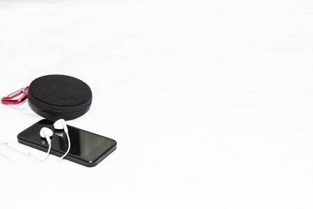 Close up smart phone speaker and headphone on the white bed in hotel holiday and relax conceptの写真素材