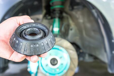 Close up old suspension rubber in the shock absorber support with car in the maintenance shop の写真素材