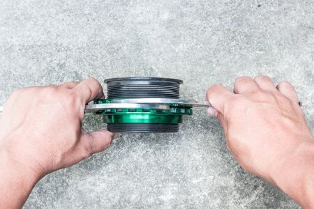 Hand a man use wrench adjust screw for up and down level shock absorber on the floor in garage modify concept of carの写真素材