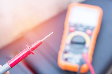 Close up Hand a man use digital multi meter or electric meter check volt of battery with motorcycle service concept の写真素材