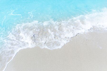 Sea wave and bubble on a sandy white beach blue sea background texture and copy space  holiday concept の写真素材