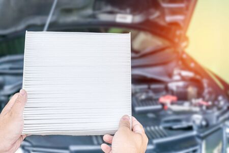 Technician checking dust on a new air filter of air conditioning system out site car service and maintenance concept of service carの写真素材