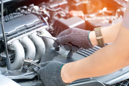 Technician is using a wrench working in auto service. Car repair and maintenance.の写真素材
