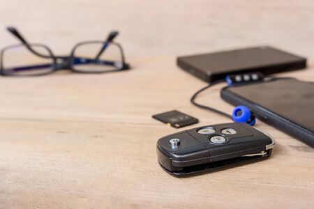 Smart phone and headset,glasses,Memory card,power bank on wood floor holiday equipment concept for touringの写真素材