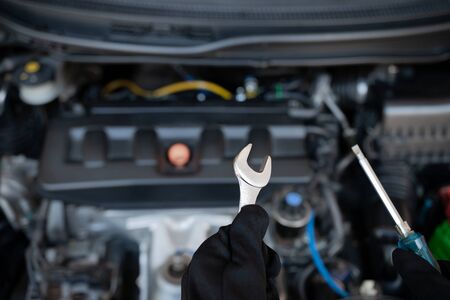 Technician is using a wrench and screwdriver for repair car in car service and maintenance conceptの写真素材