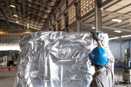 Hand worker check Plastic wrapping and plastic strap on product for protection during transport