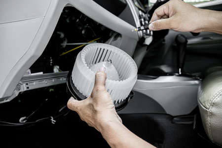 Technician in the service center install and maintenance blower air of car and use screwdriver remove a bolt in process,service conceptの写真素材