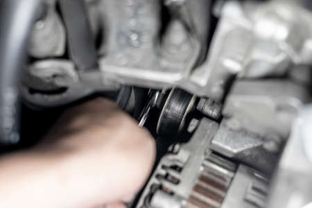 Close up Belt Tension Pulley  of car engine and a man use wrench adjust and Replacement of spare...