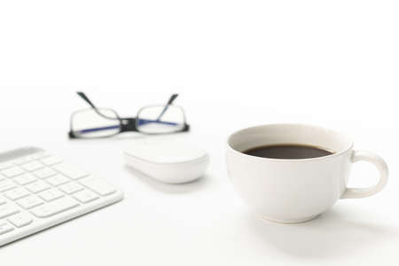 Coffee cup keyboard mouse of computer desktop in business concept on white tableの写真素材