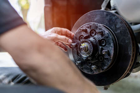 Close up disk of brake technician check drive shaft and grease in Bearing housing of wheel service checking the maintenance period of car for safety in travelの写真素材