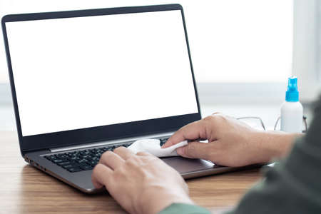 Hand a man cleaning and disinfection of workspace. Disinfecting wipes to wipe surface of desk,...