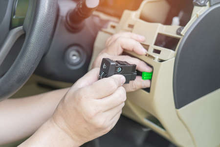 Close up hand a man hold car headlight level switch and connect to socket plug car headlight repair...