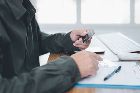 A man check number of credit card customer for pay Insurance cost and smart phone keyboard mouse...