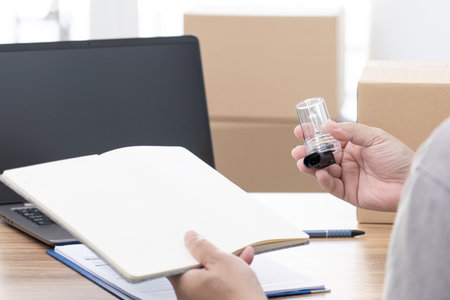 A man typing on laptop and check on parcel box about the delivery products address there was on the table to specify the address of the recipientの写真素材