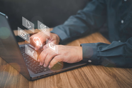 Document management and technology concept, Businessman use a laptop computer with icons on virtual screen working in office and dark cement wall backgroundの写真素材