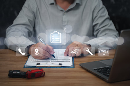 Business and car insurance concept, Man use pen checklist details of the accident use laptop and car accident model on the table with virtual screen in the backgroundの写真素材