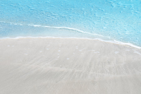 Soft blue ocean wave on sandy beach for texture copy space and backgroundの写真素材
